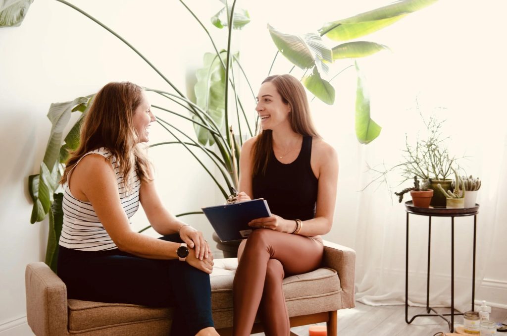 Illumera Wellness Centers Wellness professional speaking with a client in a welcoming studio