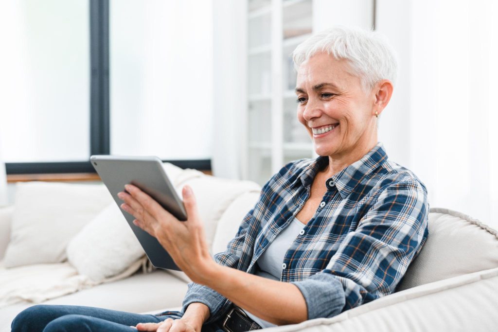 Illumera Membership Benefits Woman using a tablet at home representing Illumera membership benefits